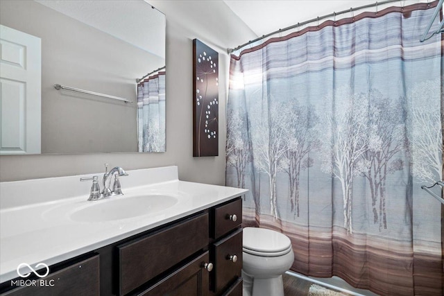 bathroom featuring toilet, a shower with shower curtain, and vanity