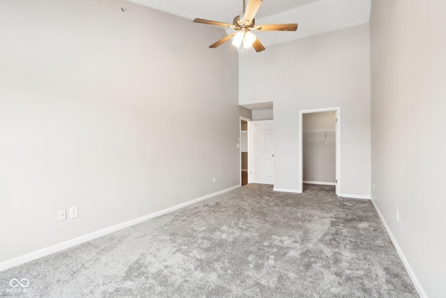 unfurnished bedroom featuring ceiling fan, light carpet, high vaulted ceiling, and a closet