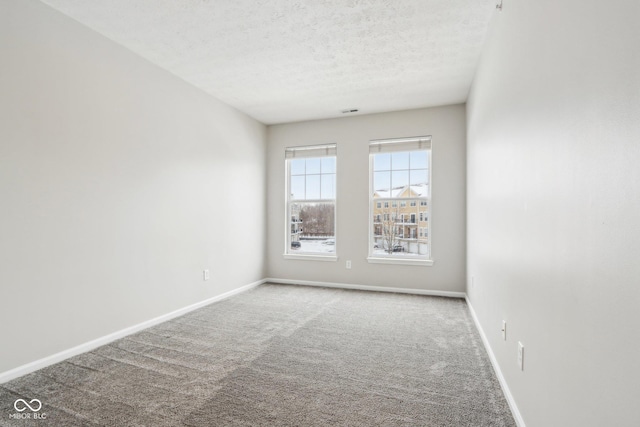 carpeted spare room featuring a textured ceiling