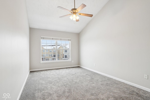 carpeted empty room featuring ceiling fan and vaulted ceiling