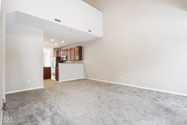 unfurnished living room featuring light carpet