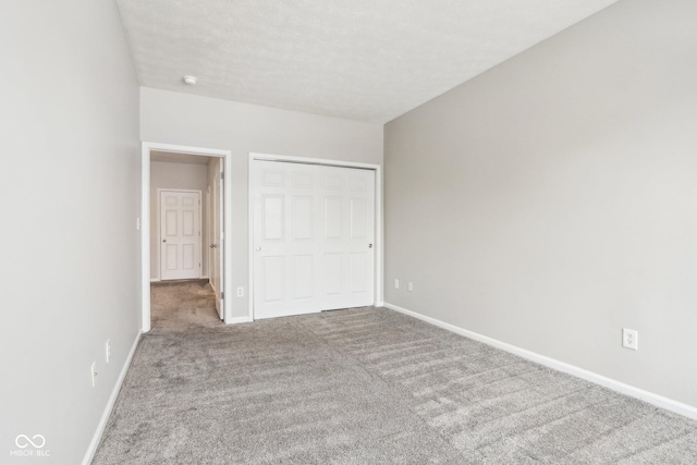 unfurnished bedroom with a closet, carpet floors, and a textured ceiling