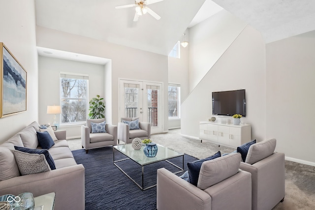 carpeted living room with ceiling fan, high vaulted ceiling, and french doors