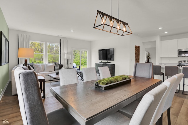 dining area with wood-type flooring and an inviting chandelier