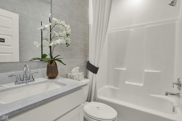 full bathroom with shower / bath combo with shower curtain, tile walls, toilet, and vanity