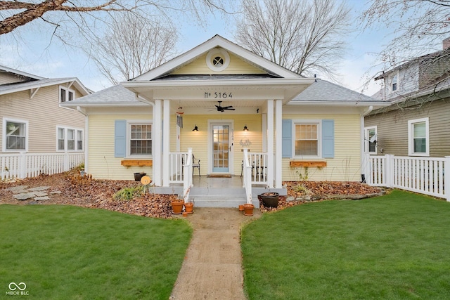 view of front of house with ceiling fan, a porch, and a front lawn