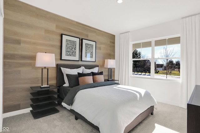 carpeted bedroom featuring wood walls