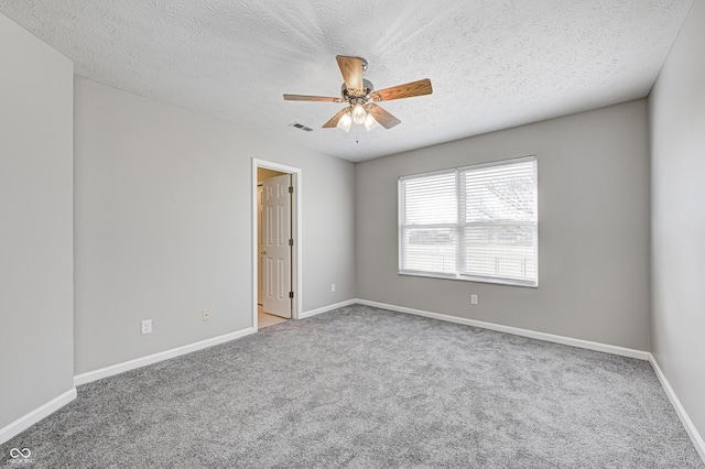 spare room featuring carpet flooring, ceiling fan, and a textured ceiling