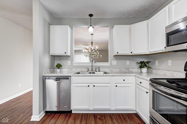 kitchen with white cabinets, decorative light fixtures, stainless steel appliances, and sink