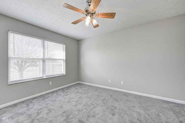 carpeted empty room featuring ceiling fan and a textured ceiling