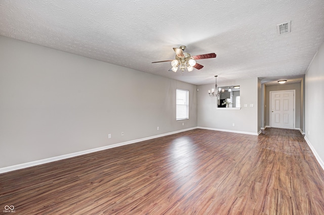 spare room with dark hardwood / wood-style flooring, ceiling fan with notable chandelier, and a textured ceiling