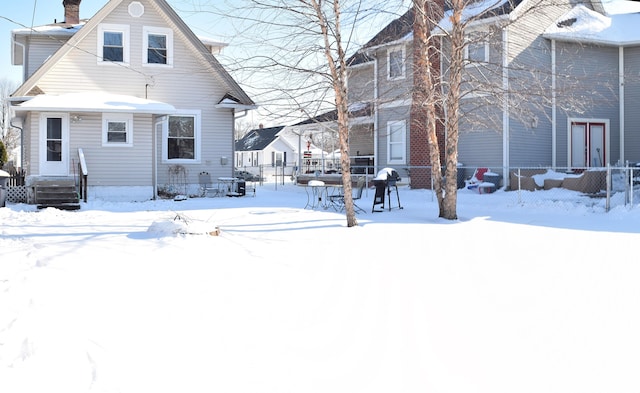 view of snow covered back of property