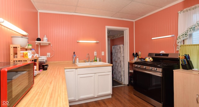 kitchen featuring stainless steel range, crown molding, sink, hardwood / wood-style flooring, and white cabinetry