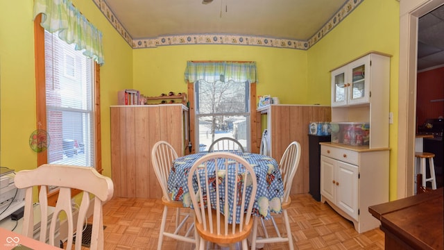 dining room with wood walls and light parquet flooring