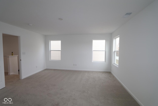 carpeted spare room featuring plenty of natural light