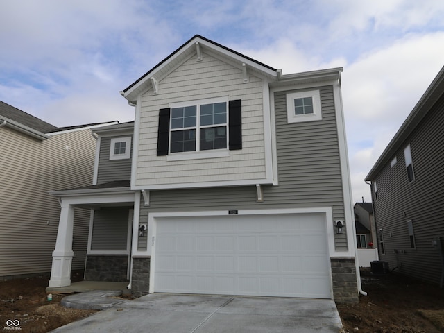 view of front of home with a garage and central AC