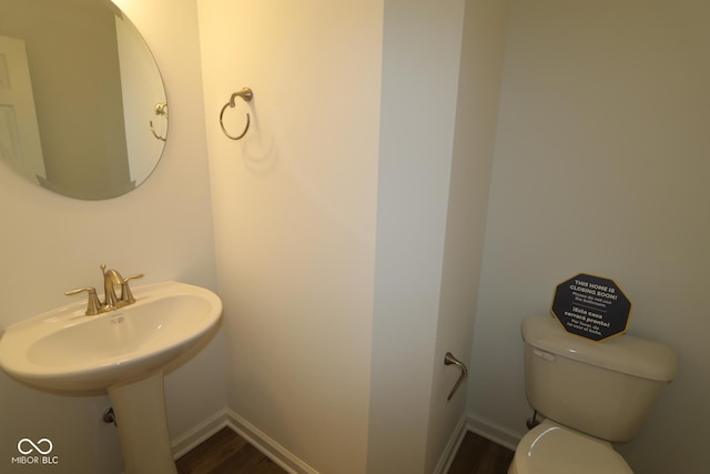 bathroom featuring wood-type flooring and toilet