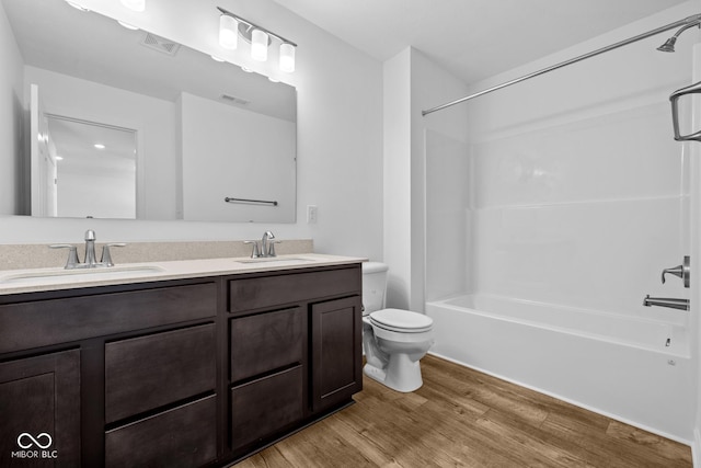 bathroom with visible vents, a sink, toilet, and wood finished floors