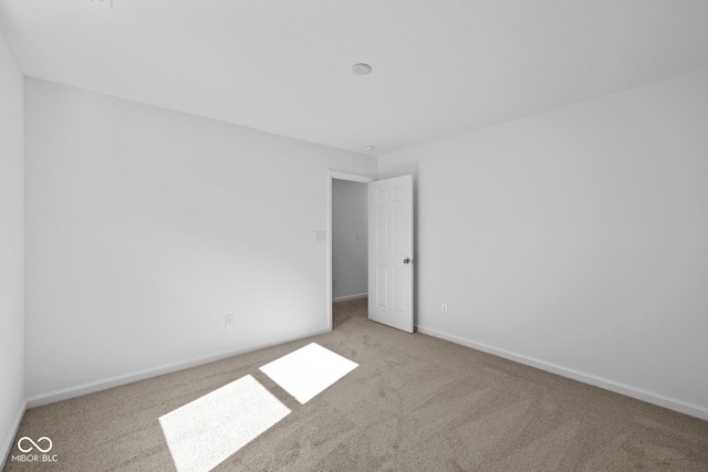 unfurnished room with carpet floors and baseboards