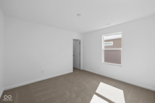 carpeted empty room featuring baseboards