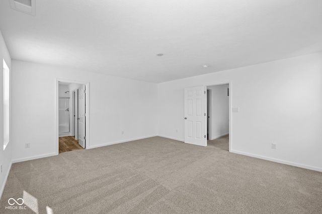 empty room with baseboards, visible vents, and carpet flooring