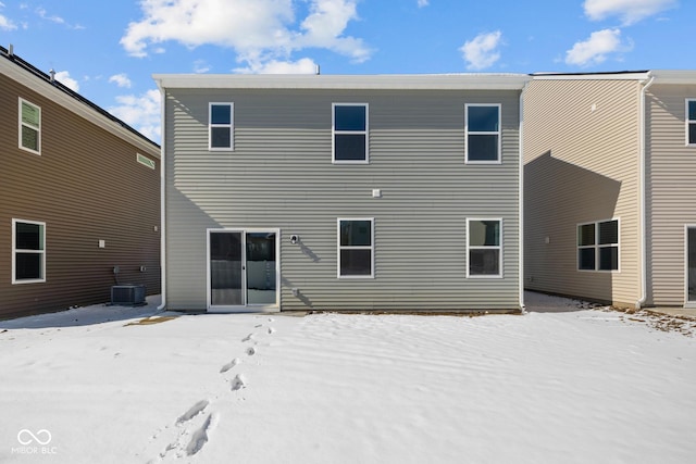 snow covered house featuring cooling unit