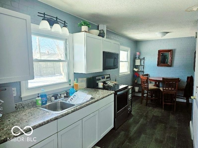 kitchen featuring dark wood finished floors, a textured ceiling, black microwave, white cabinetry, and electric range