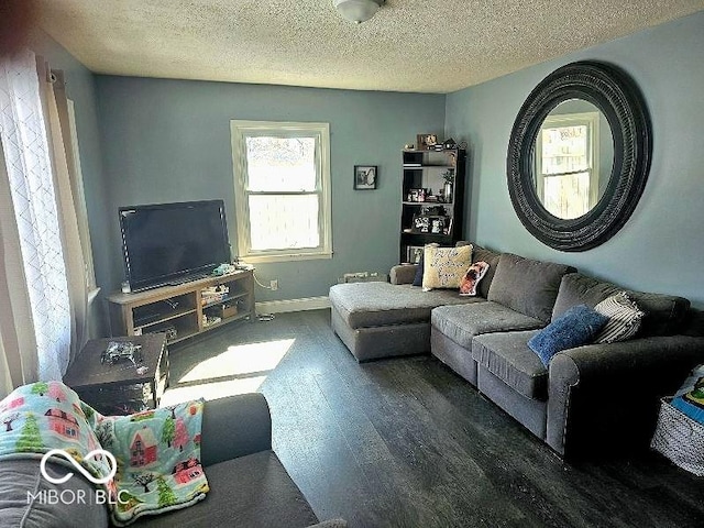 living area featuring a textured ceiling, wood finished floors, and baseboards