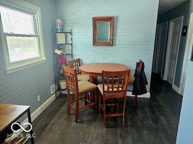 dining area with dark wood-type flooring and baseboards
