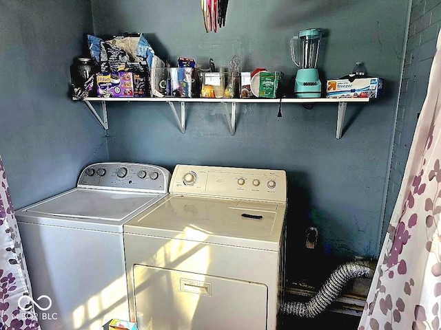 clothes washing area featuring washer and clothes dryer and laundry area