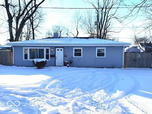 view of front of house featuring a chimney and fence