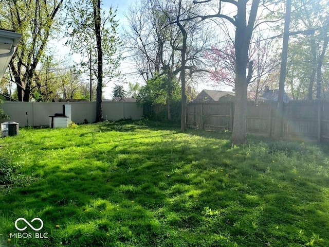view of yard featuring a fenced backyard and central air condition unit