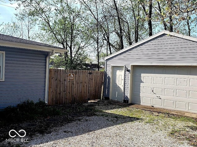 detached garage featuring fence