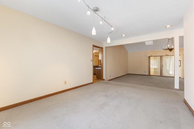 spare room with light colored carpet and a chandelier