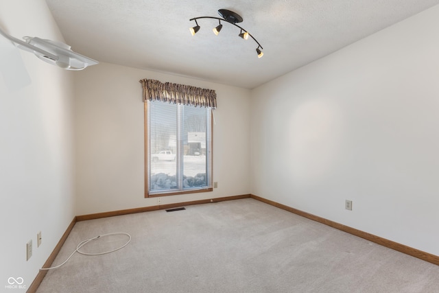 spare room featuring light colored carpet