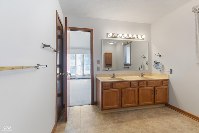 bathroom featuring tile patterned floors, vanity, and a textured ceiling