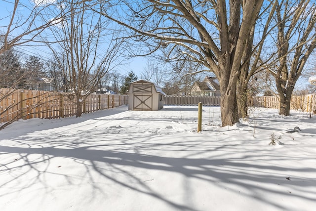 yard covered in snow with a storage shed