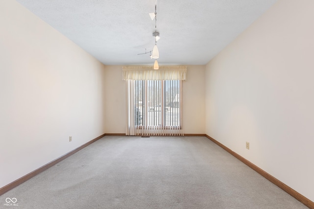 empty room with a textured ceiling and carpet floors