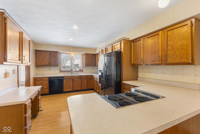 kitchen with kitchen peninsula, sink, refrigerator with ice dispenser, dishwasher, and stovetop