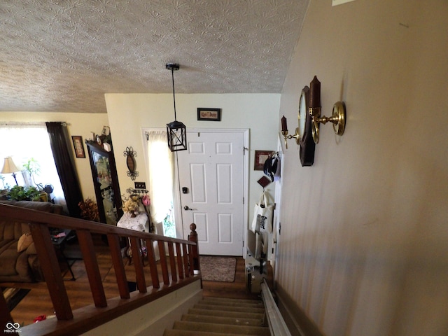 staircase featuring a textured ceiling