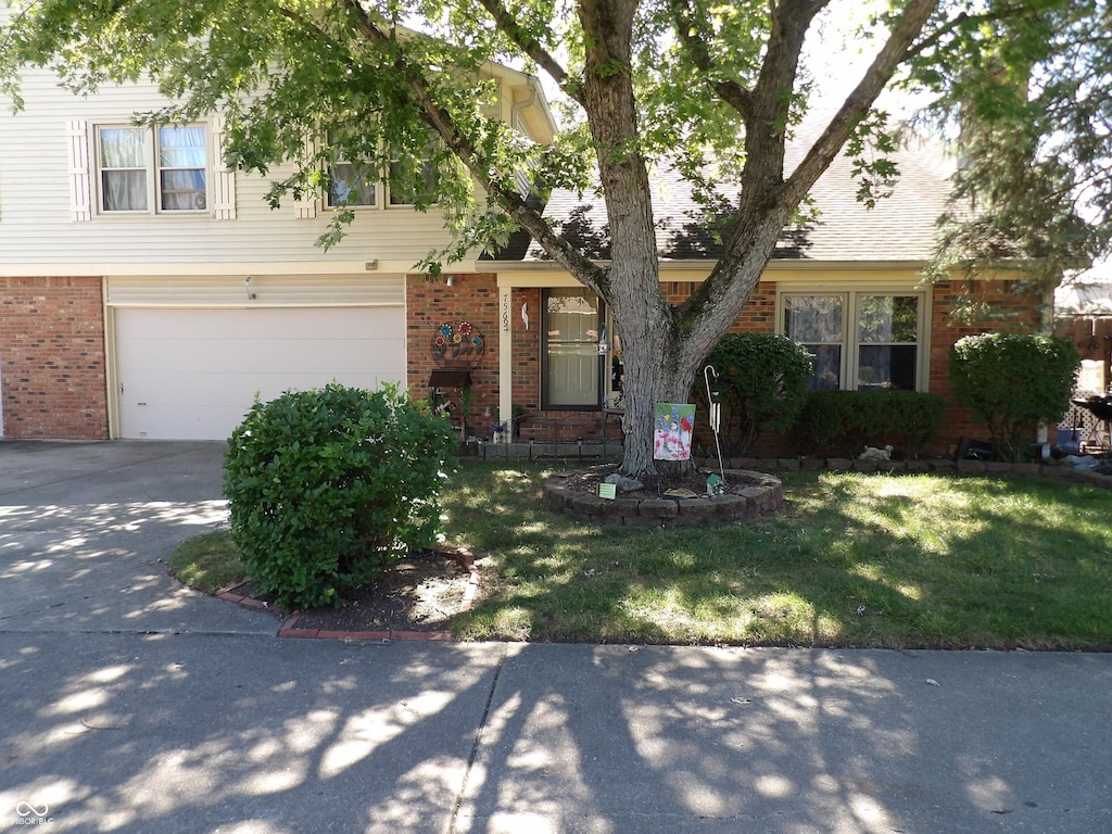 7569 Farm View Cir E, Indianapolis, IN 46256 - view of front of property with brick siding, concrete driveway, a front yard, and a garage