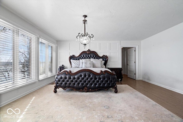 bedroom with wood-type flooring and an inviting chandelier