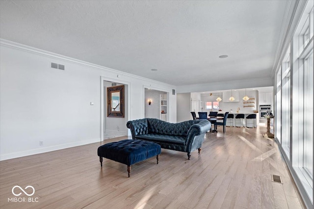 living room with crown molding and light hardwood / wood-style floors