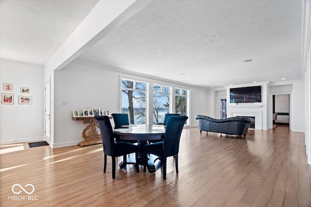 dining room with hardwood / wood-style floors, crown molding, and a textured ceiling