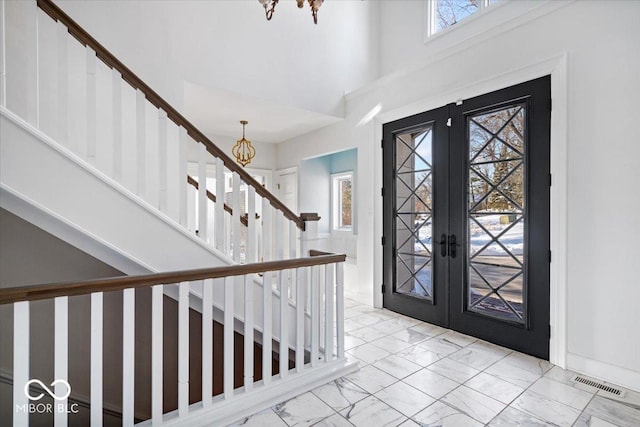 entryway with french doors and an inviting chandelier