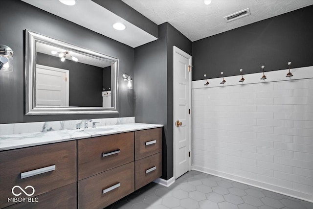 bathroom featuring tile patterned floors, vanity, and a textured ceiling