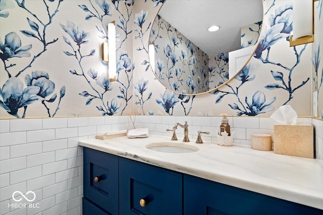 bathroom with vanity and tile walls