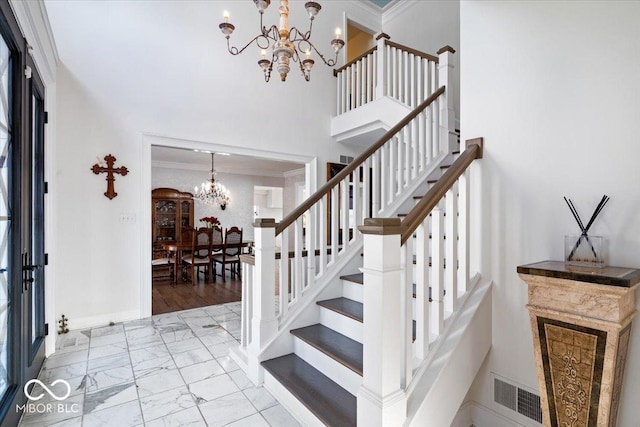 stairway featuring crown molding and a chandelier