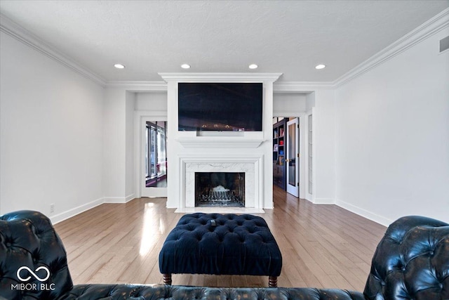 living room featuring wood-type flooring, crown molding, and a high end fireplace