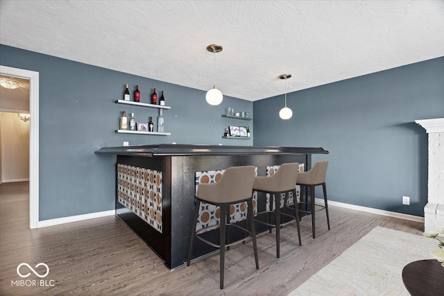 bar featuring hardwood / wood-style floors and pendant lighting